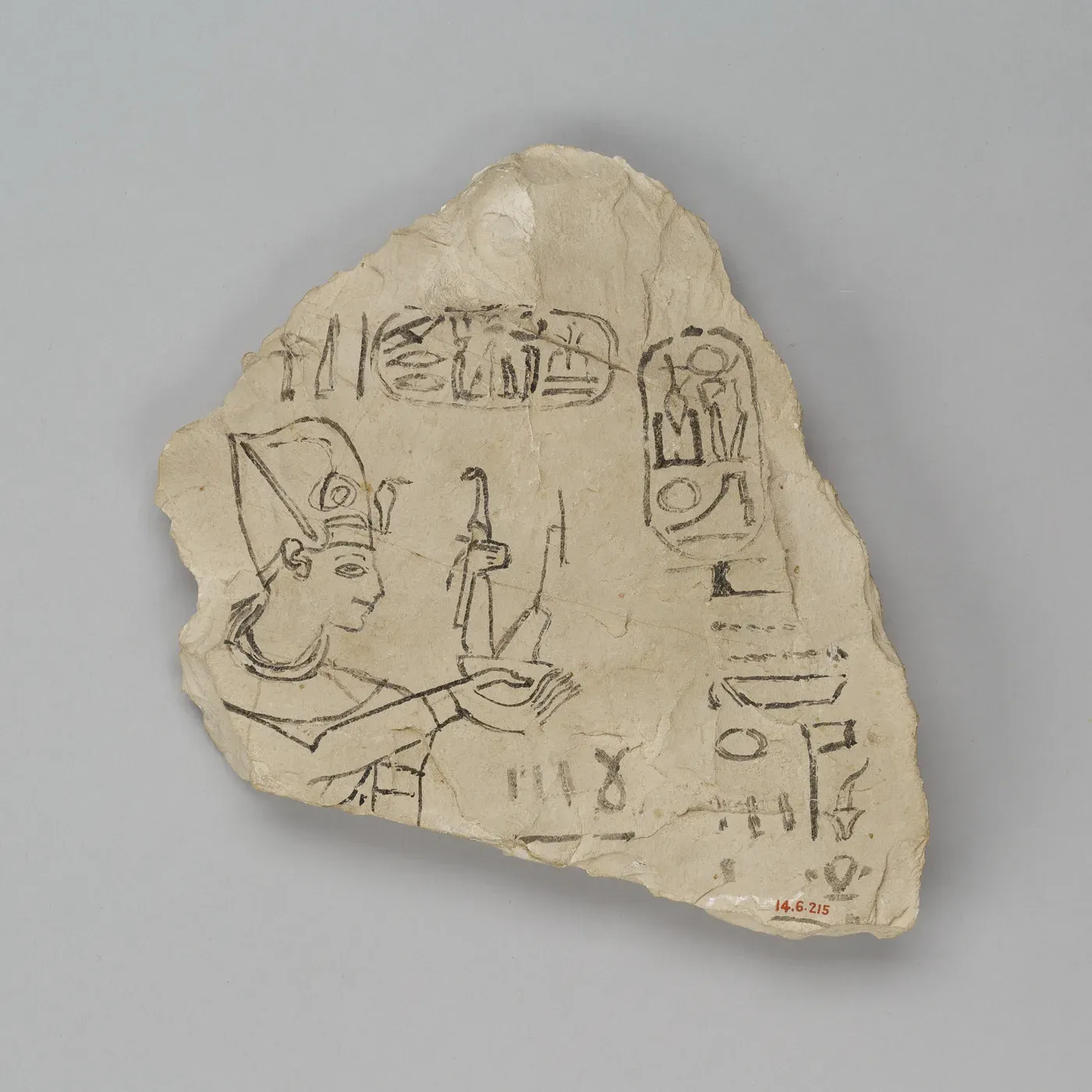 A flake of pale limestone with an ink drawing. A king in profile, wearing a tall rounded crown with a cobra at the brow, holds out one hand, and on his palm sits a small figure with a feather on her head. Two oval name-rings and other hieroglyphs are sketched above and beside him.