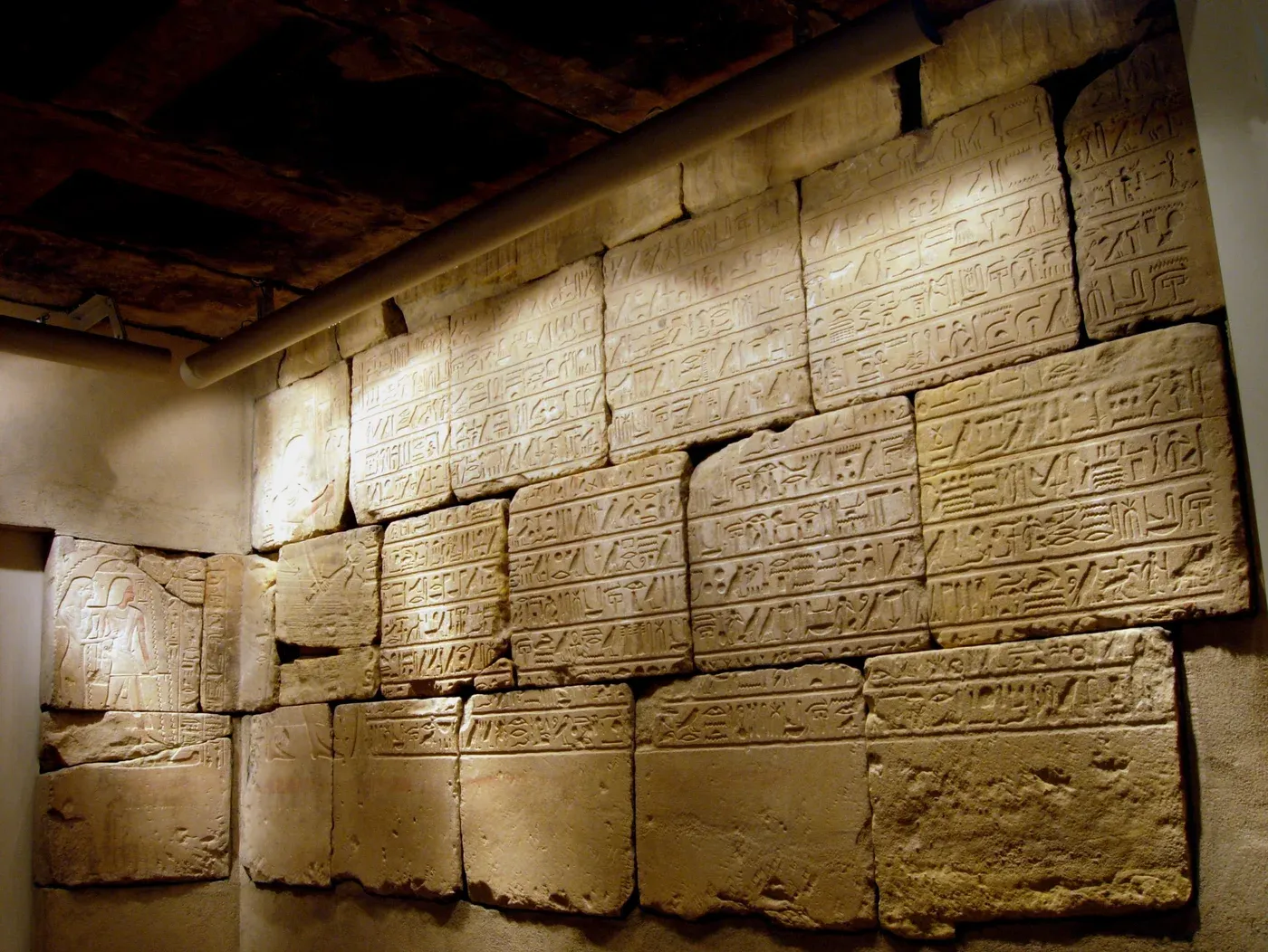 The museum installation of Sobekmose's sandstone burial chamber, with carved figures and hieroglyphic inscriptions across its walls and ceiling.